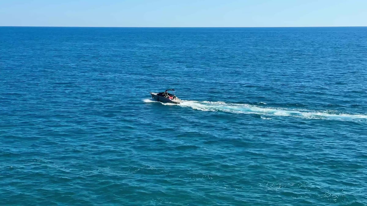 Jet skiing across calm blue ocean water on a sunny day